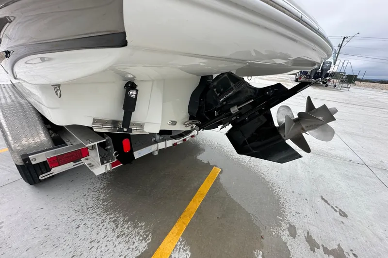 Slide: The Image of 2023 Crownline 290 CR boat stern with dual propellers on a trailer. - 55