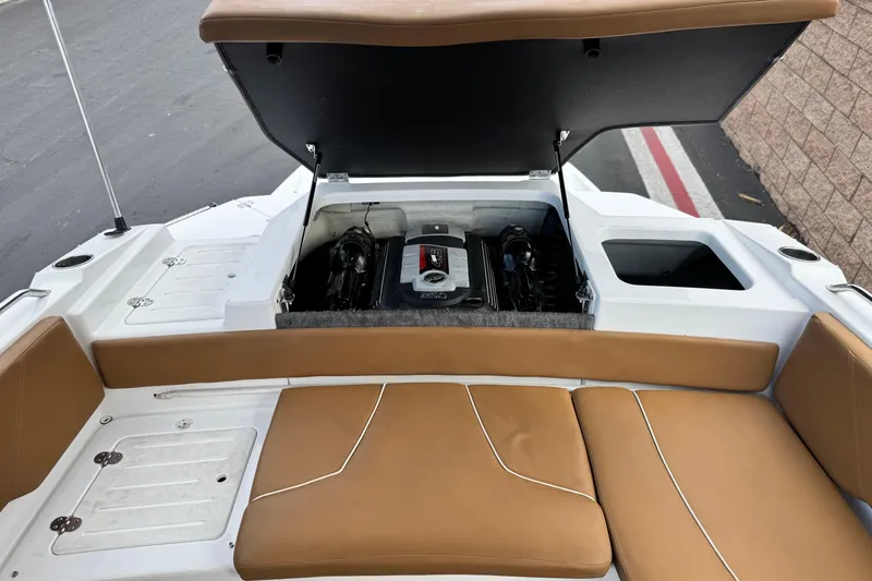 Slide: The Image of 2021 Glastron 205 boat engine compartment with tan seating and open hatch. - 17