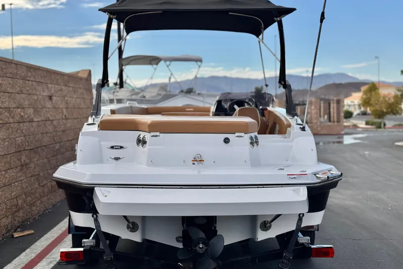 Slide: The Image of 2021 Glastron 205 boat, rear view, parked outdoors with canopy and tan seating. - 4