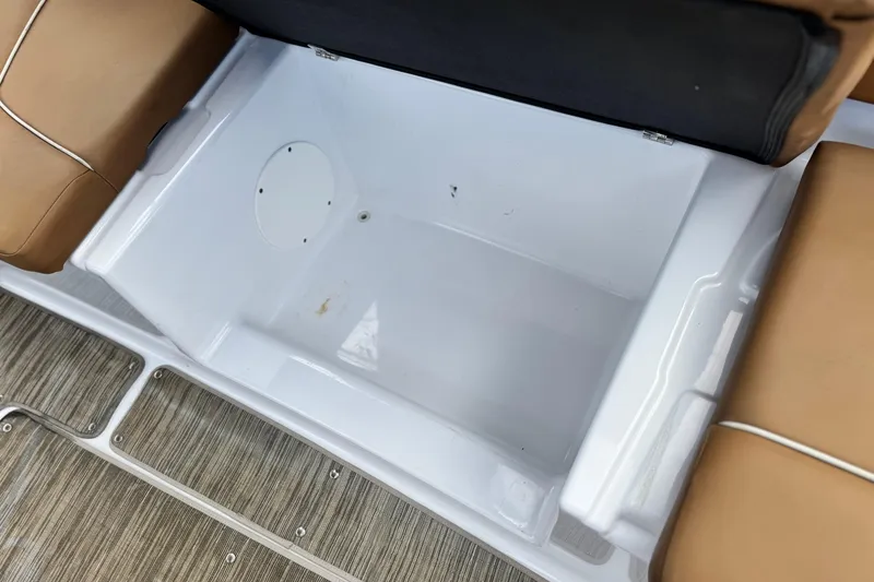 Slide: The Image of 2021 Glastron 205 boat storage compartment with tan seating and wood-textured flooring. - 15