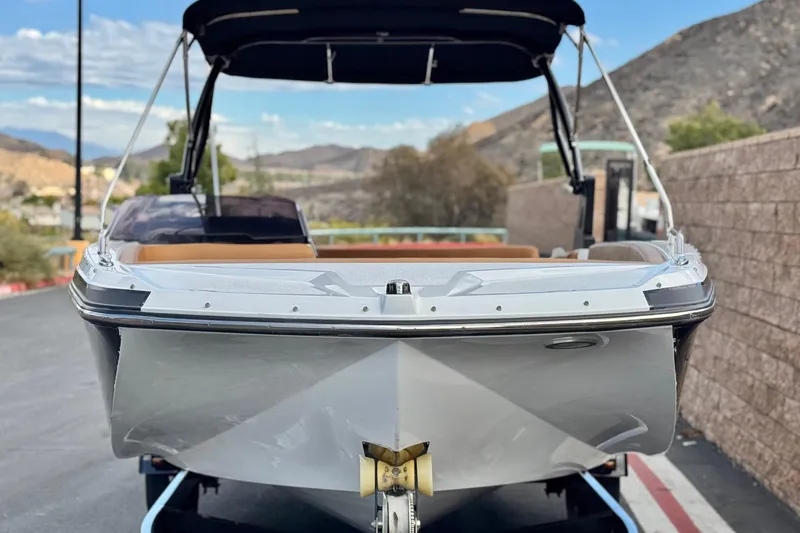 Slide: The Image of 2021 Glastron 205 boat on trailer, scenic mountain backdrop, sunny day. - 2