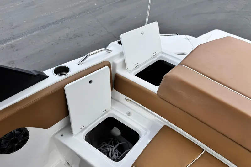 Slide: The Image of 2021 Glastron 205 boat interior with open storage compartments and tan seating. - 20