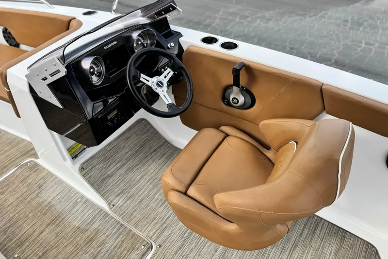 Slide: The Image of 2021 Glastron 205 boat interior with tan leather seat and modern dashboard. - 21