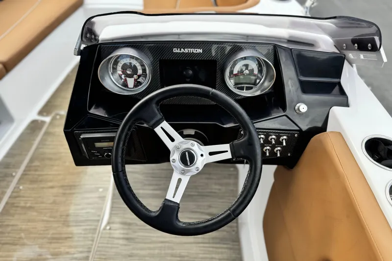 Slide: The Image of Steering wheel and dashboard of 2021 Glastron 205 boat, featuring modern controls and gauges. - 22