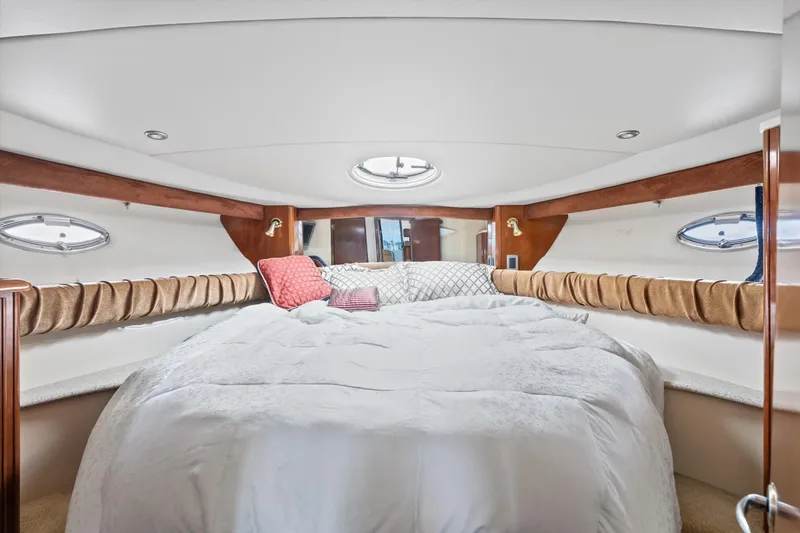 Slide: The Image of Luxurious bedroom interior of 2006 Meridian 411 Sedan yacht with plush bedding and porthole windows. - 15