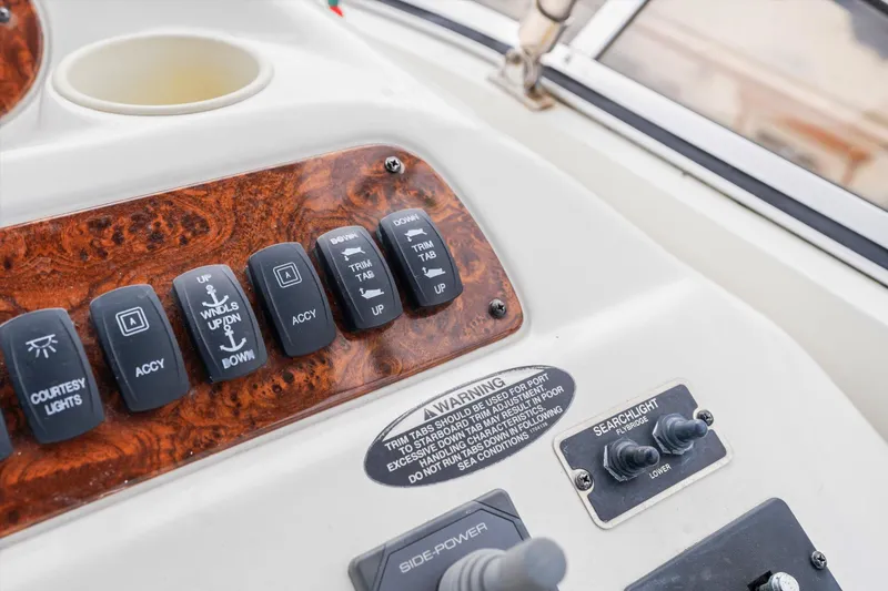 Slide: The Image of Control panel of a 2006 Meridian 411 Sedan boat with various switches and warning label. - 21