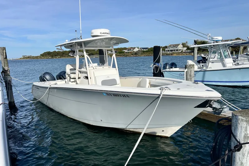 Slide: The Image of 2018 Cobia 227 boat docked in a marina with clear blue water. - 1