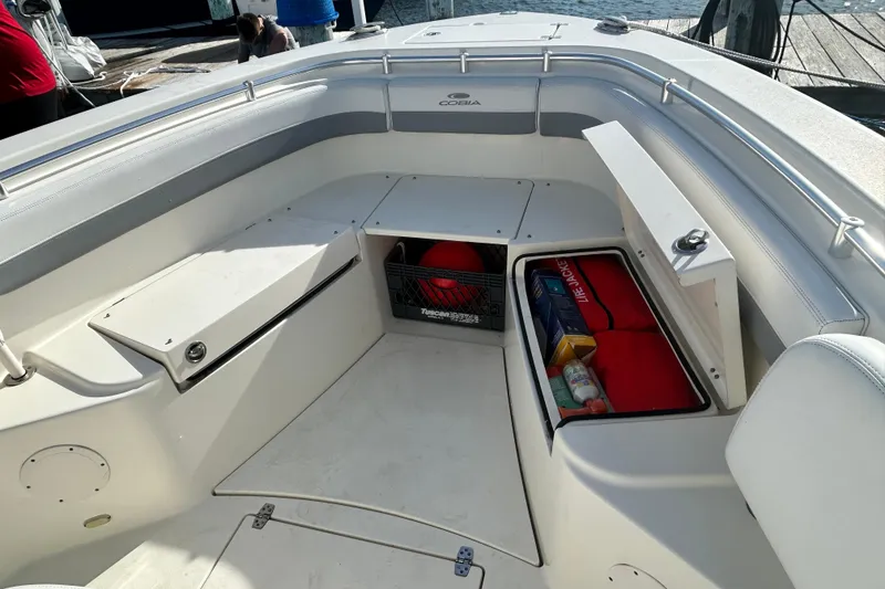 Slide: The Image of 2018 Cobia 227 boat interior with open storage compartments and safety equipment. - 11