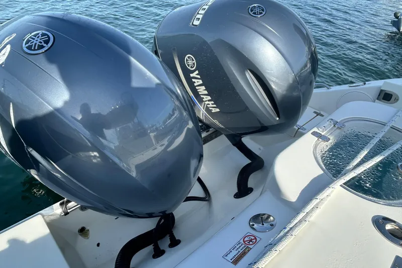 Slide: The Image of Twin Yamaha outboard engines on a 2018 Cobia 227 boat, docked on water. - 12