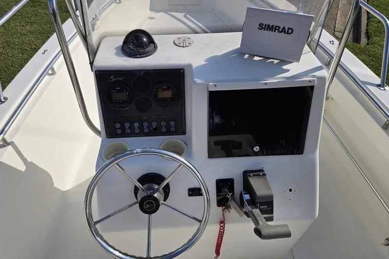 Slide: The Image of Control panel of a 2000 Scout 185 Sportfish boat with steering wheel and Simrad equipment. - 5