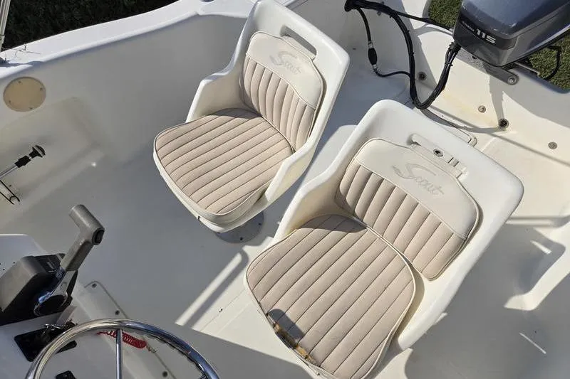 Slide: The Image of 2000 Scout 185 Sportfish boat interior with two beige seats and steering wheel. - 9