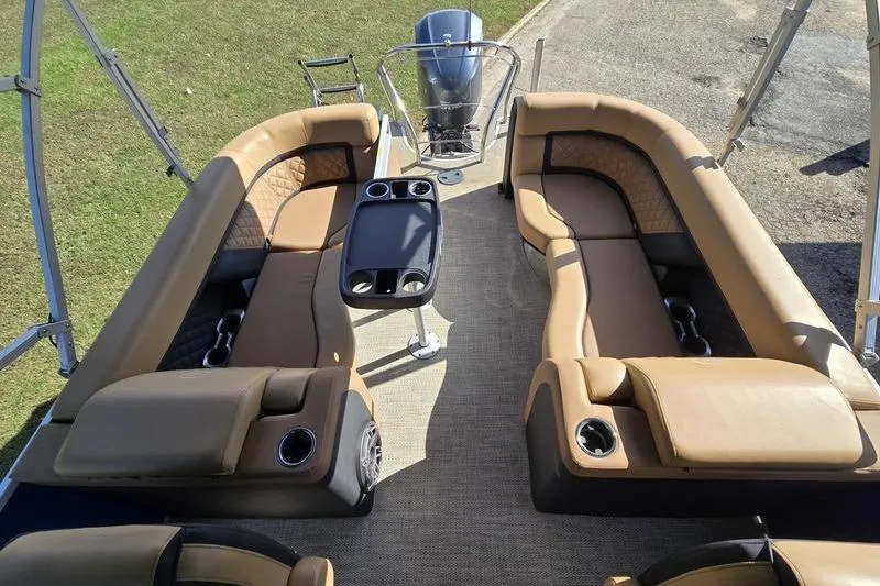 Slide: The Image of Luxurious seating on 2023 Godfrey AquaPatio 255 SBW pontoon boat, featuring a center table. - 12