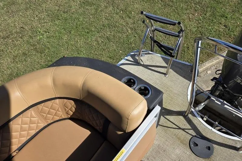 Slide: The Image of 2023 Godfrey AquaPatio 255 SBW boat interior with tan seating and stainless steel ladder. - 16