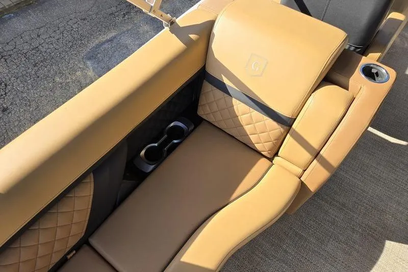 Slide: The Image of Luxurious tan seating on 2023 Godfrey AquaPatio 255 SBW iMPACT boat with cup holders. - 22