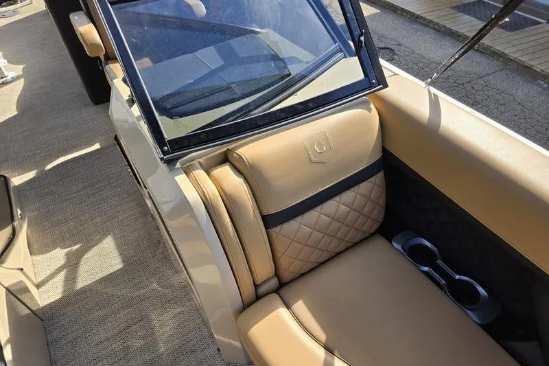 Slide: The Image of 2023 Godfrey AquaPatio 255 SBW iMPACT boat interior with tan quilted seating and cup holders. - 26