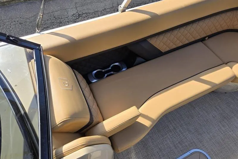Slide: The Image of Luxurious tan seating on 2023 Godfrey AquaPatio 255 SBW iMPACT boat with cup holders. - 30
