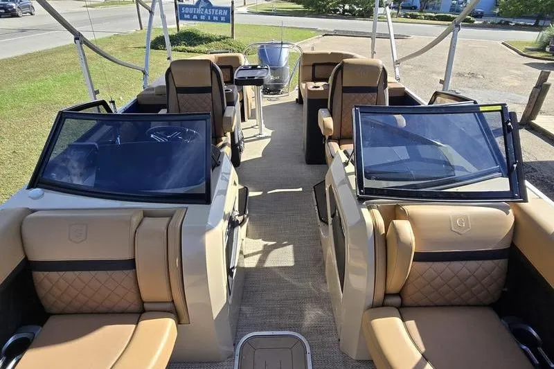 Slide: The Image of 2023 Godfrey AquaPatio 255 SBW iMPACT boat interior with luxurious seating and helm. - 7