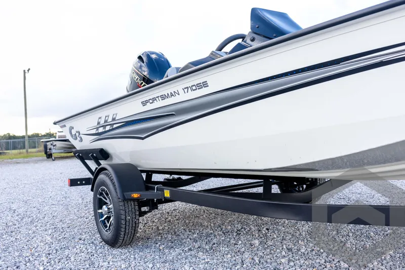 Slide: The Image of 2026 G3 Sportsman 1710 SE boat on trailer, side view, parked on gravel. - 13
