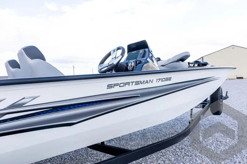 Slide: The Image of 2026 G3 Sportsman 1710 SE boat, sleek design, parked on gravel. - 14