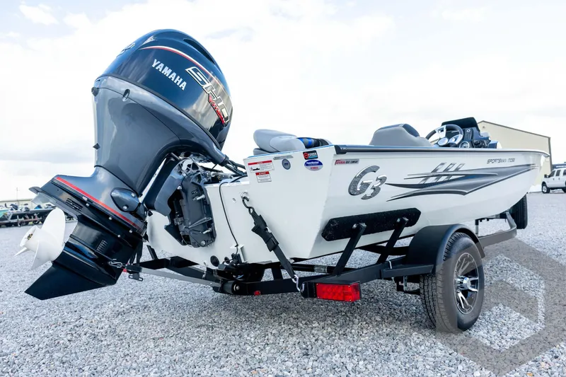Slide: The Image of 2026 G3 Sportsman 1710 SE boat with Yamaha engine on trailer, parked on gravel. - 17