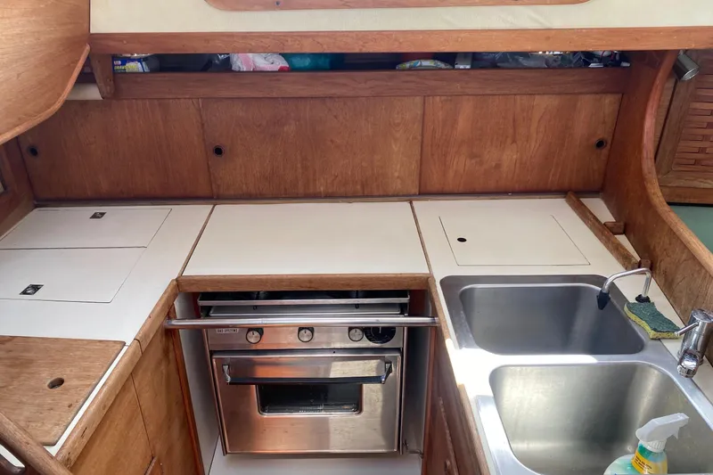 Slide: The Image of 1984 Sabre MK 1 yacht kitchen with stove, sink, and wooden cabinetry. - 8