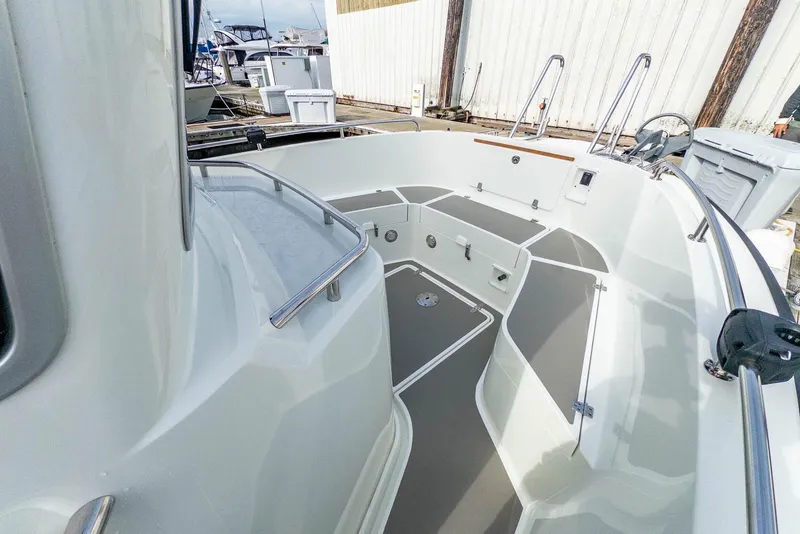 Slide: The Image of 2019 Targa 27.2 boat deck with seating and storage at a marina. - 13