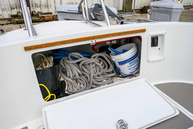 Slide: The Image of Storage compartment of a 2019 Targa 27.2 boat with ropes and cleaning supplies. - 14