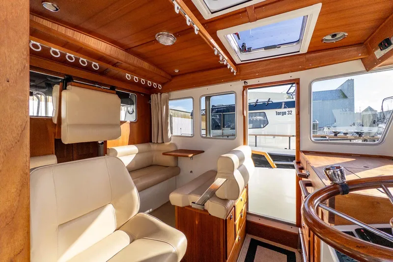 Slide: The Image of Interior of 2019 Targa 27.2 boat with wooden finish and beige seating. - 16