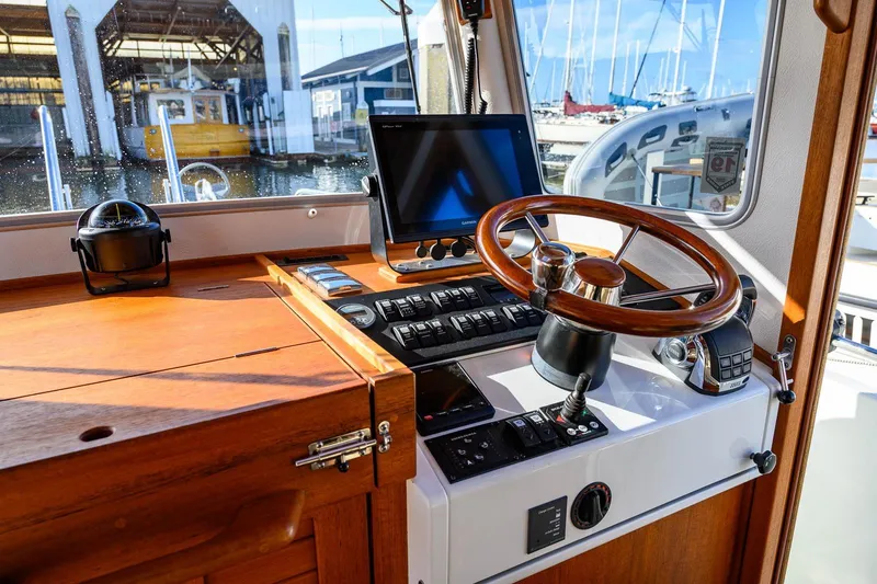 Slide: The Image of 2019 Targa 27.2 boat helm with wooden steering wheel and navigation equipment. - 18