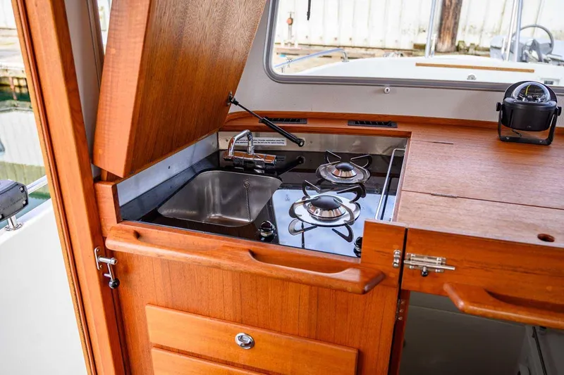 Slide: The Image of Compact kitchen area on 2019 Targa 27.2 boat with stove and sink. - 19