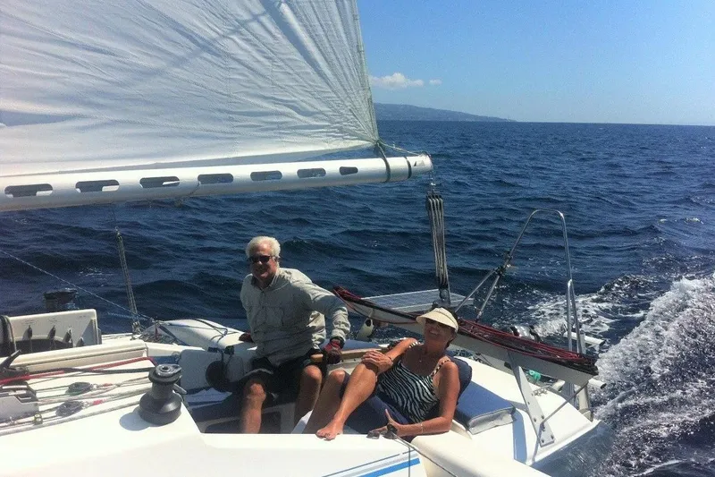 The Image of Couple sailing on 2001 Corsair 31 UC boat in open sea. - 1