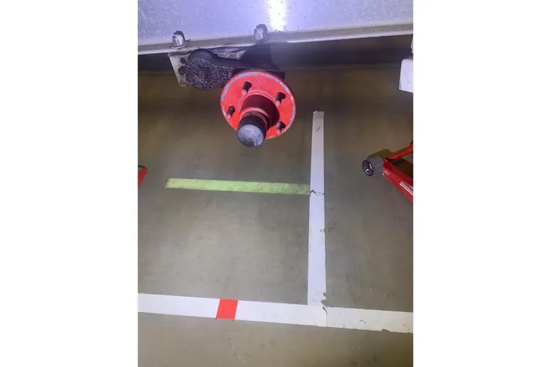 Slide: The Image of Red axle hub of 2001 Corsair 31 UC trailer on concrete floor. - 15