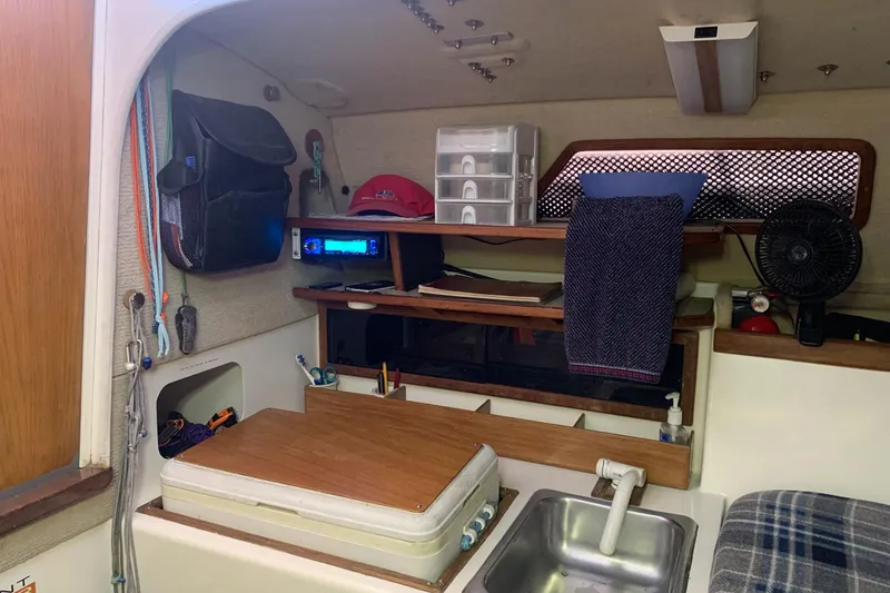 Slide: The Image of Interior of a 2001 Corsair 31 UC sailboat with compact kitchen setup. - 5