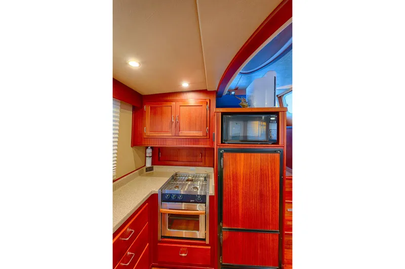 Slide: The Image of 2007 American Tug 41 galley with wood cabinetry, stove, microwave, and refrigerator. - 11