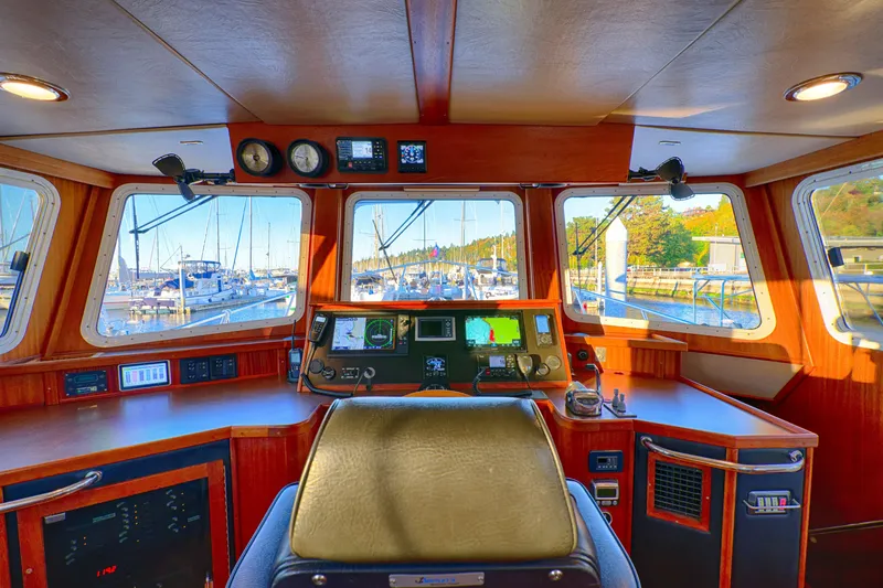 Slide: The Image of Interior view of 2007 American Tug 41 helm with navigation equipment and marina view. - 12