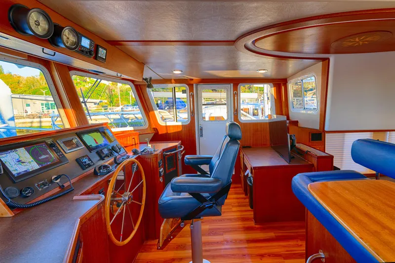 Slide: The Image of Interior of 2007 American Tug 41, featuring helm, navigation equipment, and wooden finishes. - 14