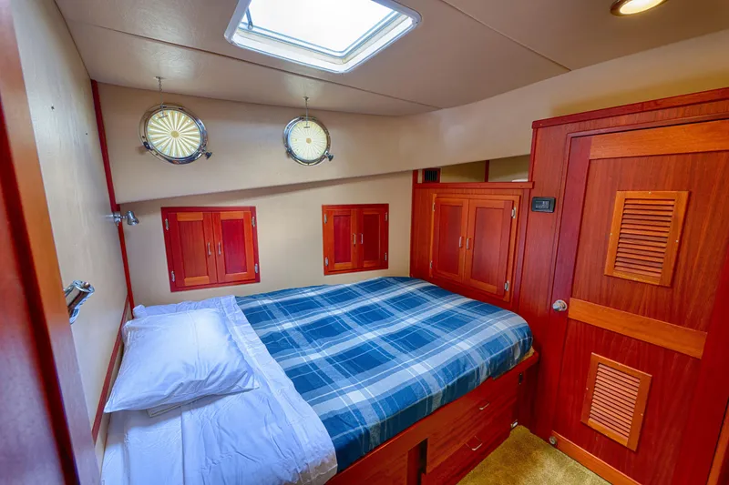 Slide: The Image of Cozy cabin interior of 2007 American Tug 41 with plaid bedding and wooden cabinetry. - 16