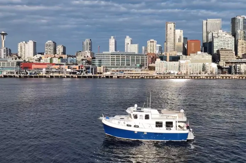Slide: The Image of 2007 American Tug 41 cruising near city skyline with iconic tower. - 29