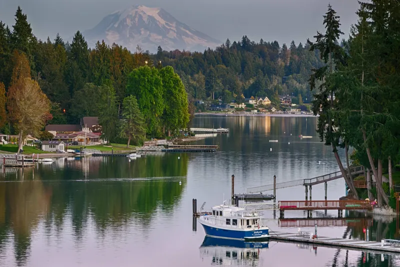 Slide: The Image of American Tug 41 (2007) docked on serene lake with forested backdrop and mountain view. - 30