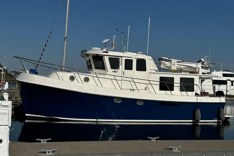 Slide: The Image of 2007 American Tug 41 boat docked at marina, featuring blue hull and white cabin. - 31