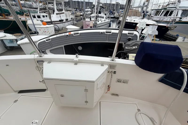 Slide: The Image of 2007 American Tug 41 at marina, featuring deck and Suzuki outboard motor. - 35