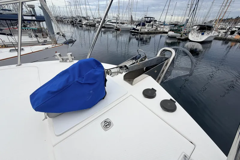 Slide: The Image of Bow of 2007 American Tug 41 in marina, featuring anchor and blue cover. - 37