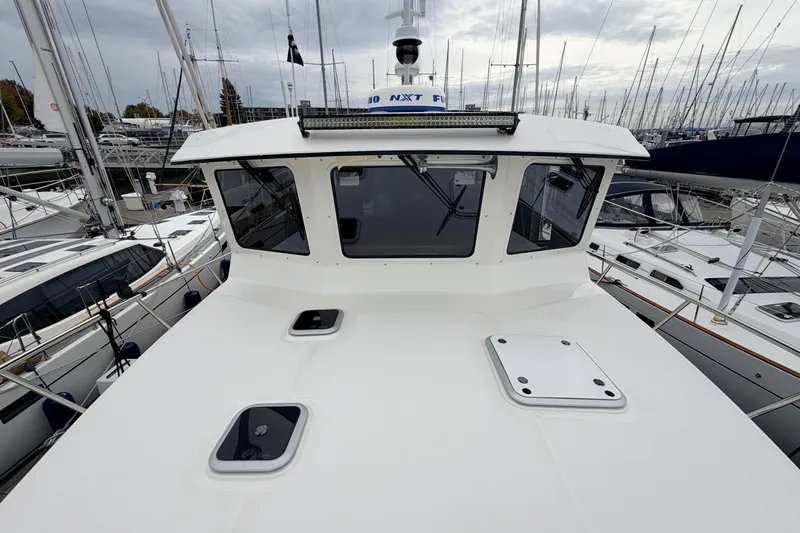 Slide: The Image of 2007 American Tug 41 boat docked among sailboats under cloudy skies. - 38
