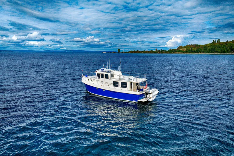 Slide: The Image of 2007 American Tug 41 cruising on open water under a partly cloudy sky. - 6