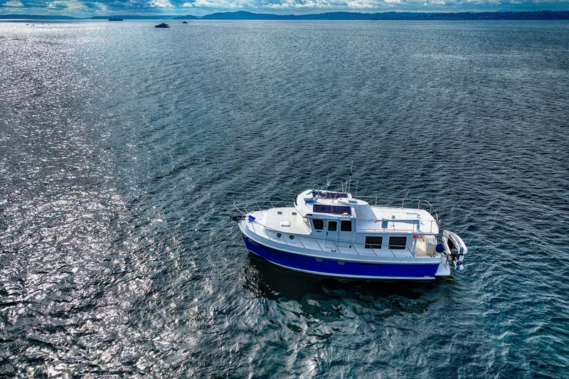 Slide: The Image of 2007 American Tug 41 cruising on open water under a cloudy sky. - 7