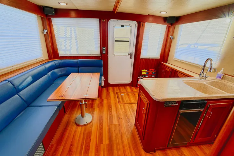 Slide: The Image of Luxurious interior of a 2007 American Tug 41 with wood flooring and blue seating. - 9