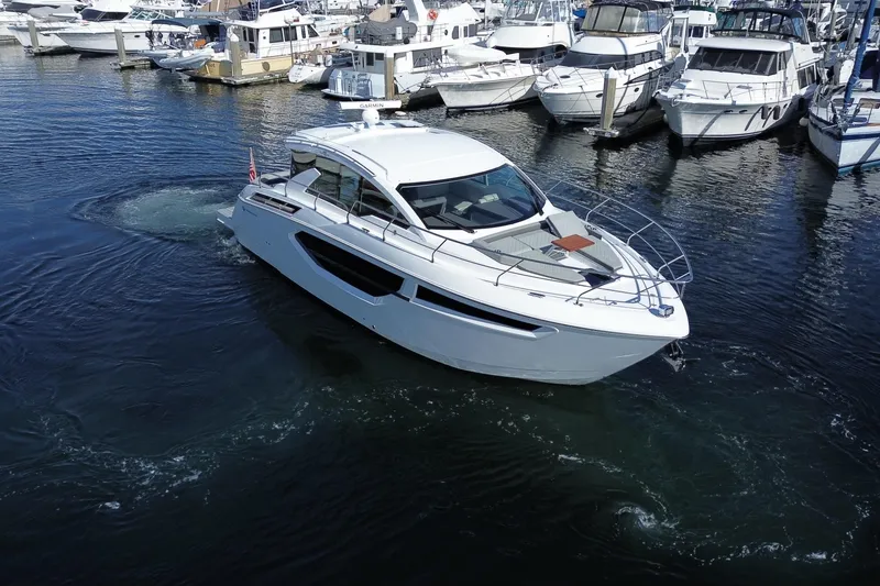 Slide: The Image of 2022 Cruisers Yachts 42 Cantius in marina, surrounded by other boats. - 25