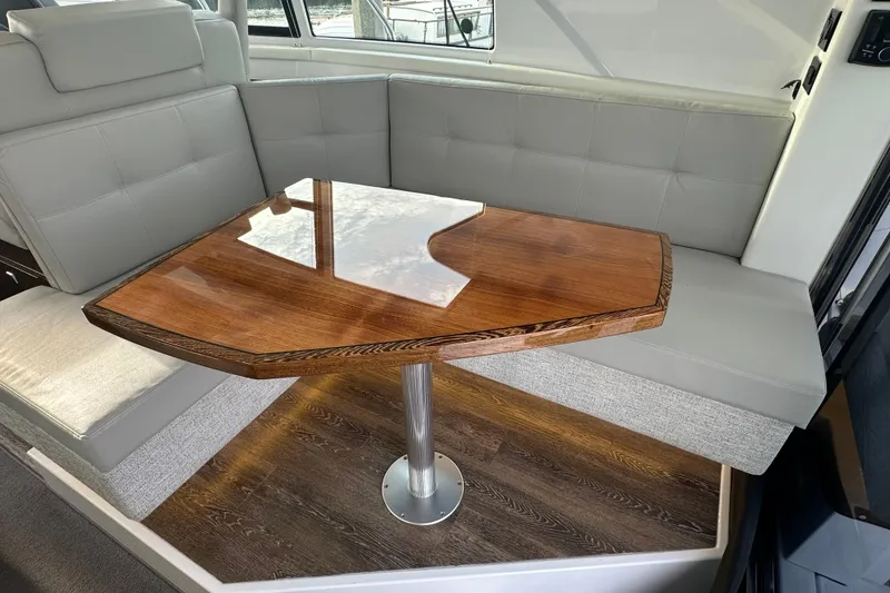 Slide: The Image of Luxurious interior of 2022 Cruisers Yachts 42 Cantius with elegant wooden table and plush seating. - 29