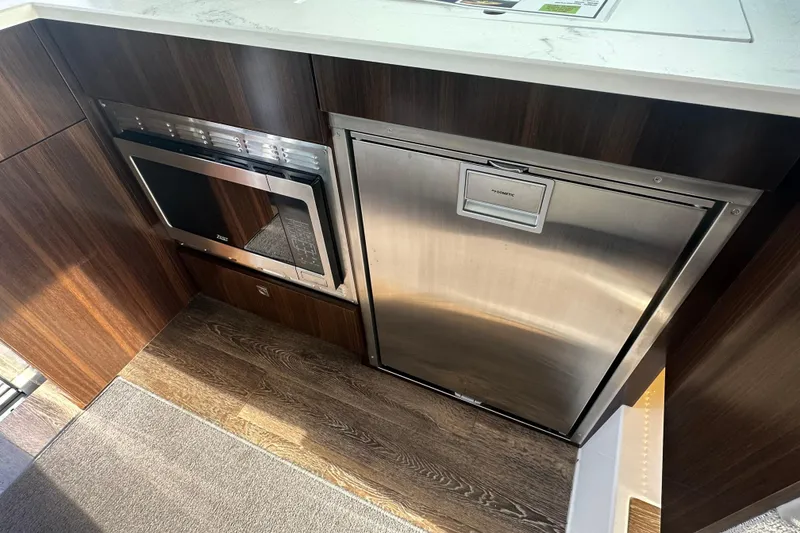 Slide: The Image of Modern kitchen area in 2022 Cruisers Yachts 42 Cantius with microwave and fridge. - 32