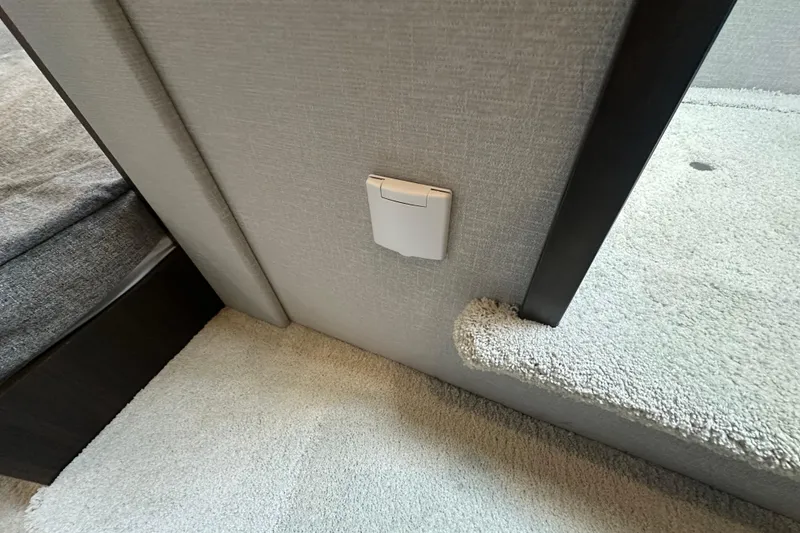 Slide: The Image of Interior detail of 2022 Cruisers Yachts 42 Cantius, featuring a wall outlet and carpeted flooring. - 34